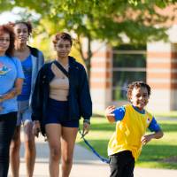 Family walking with small child on sidewalk of Kirkhof Lawn.